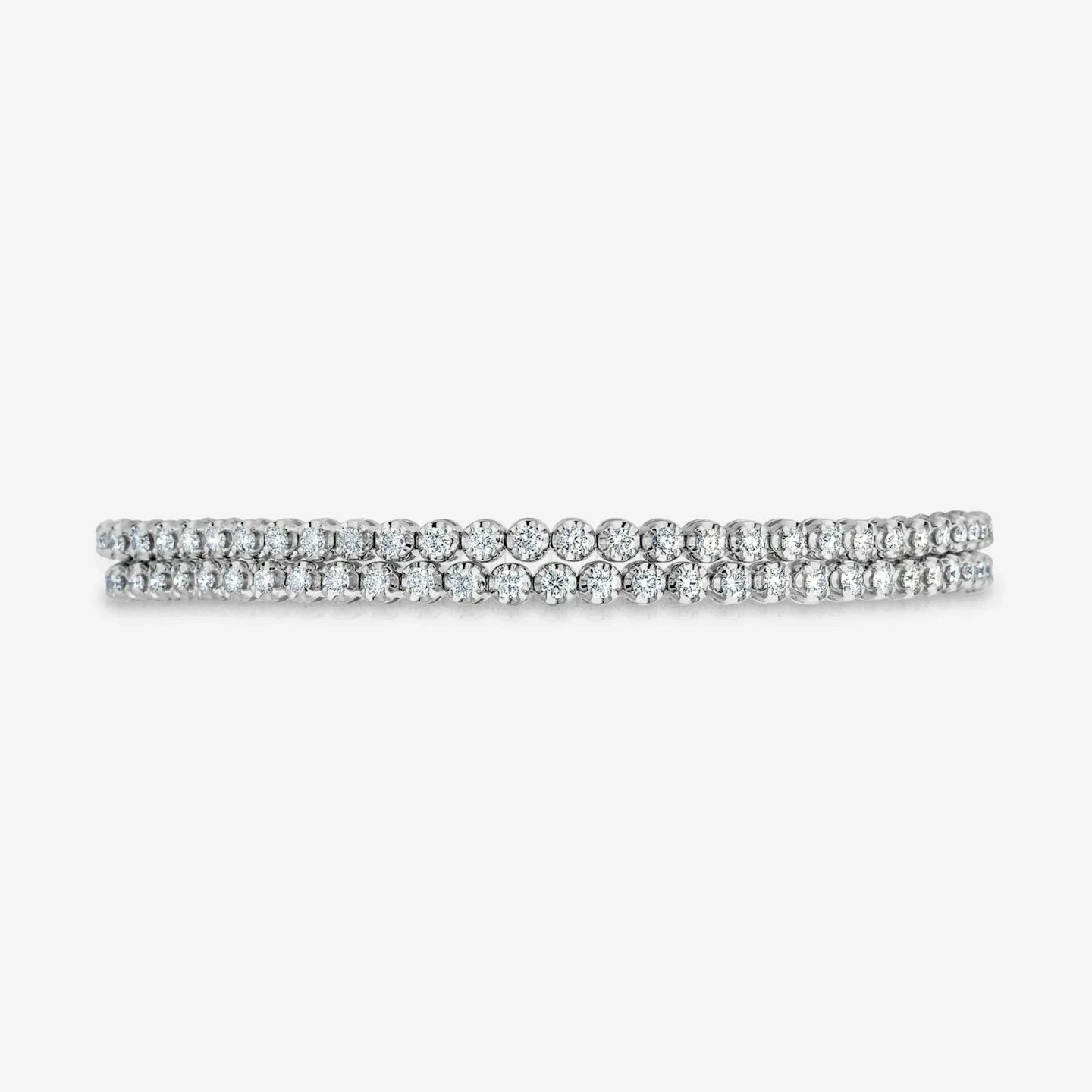 Two diamond tennis bracelets side-by-side on a grey background.