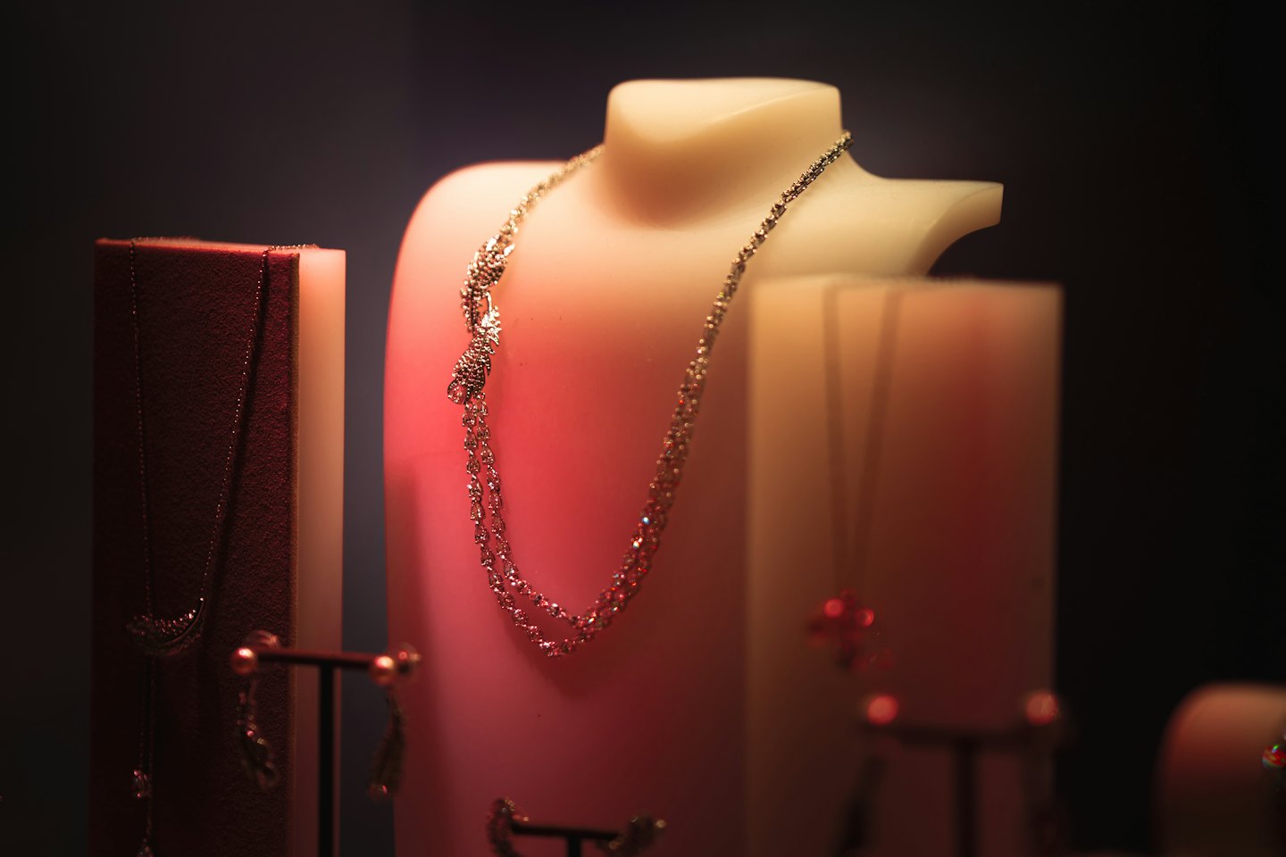 Jewelry pieces displayed on white stands and a velvet cloth.
