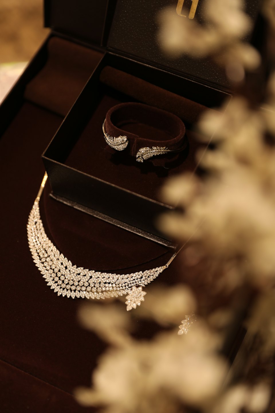 A diamond necklace and bracelet rest inside a velvet jewelry box.